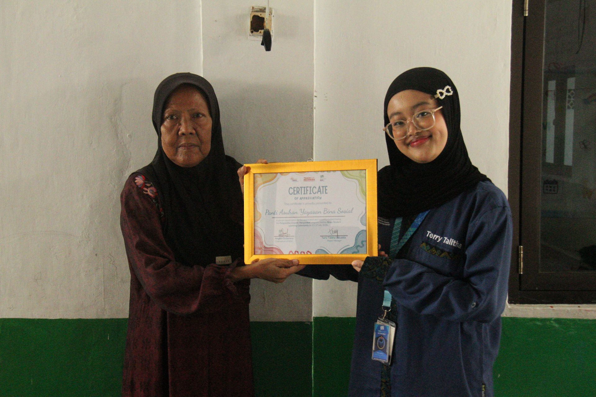 Penyerahan sertifikat dari panitia PkM BSLC 2026 kepada perwakilan Panti Asuhan Yayasan Bina Sosial