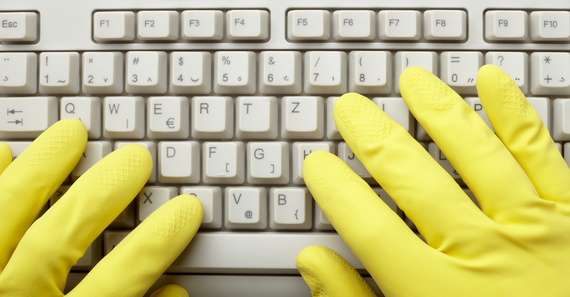 close up of desktop computer keyboard an dhands with gloves